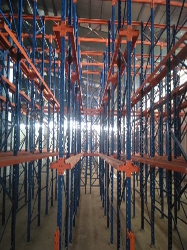 Blue and orange steel racking bays running the depth of the Payra Port warehouse