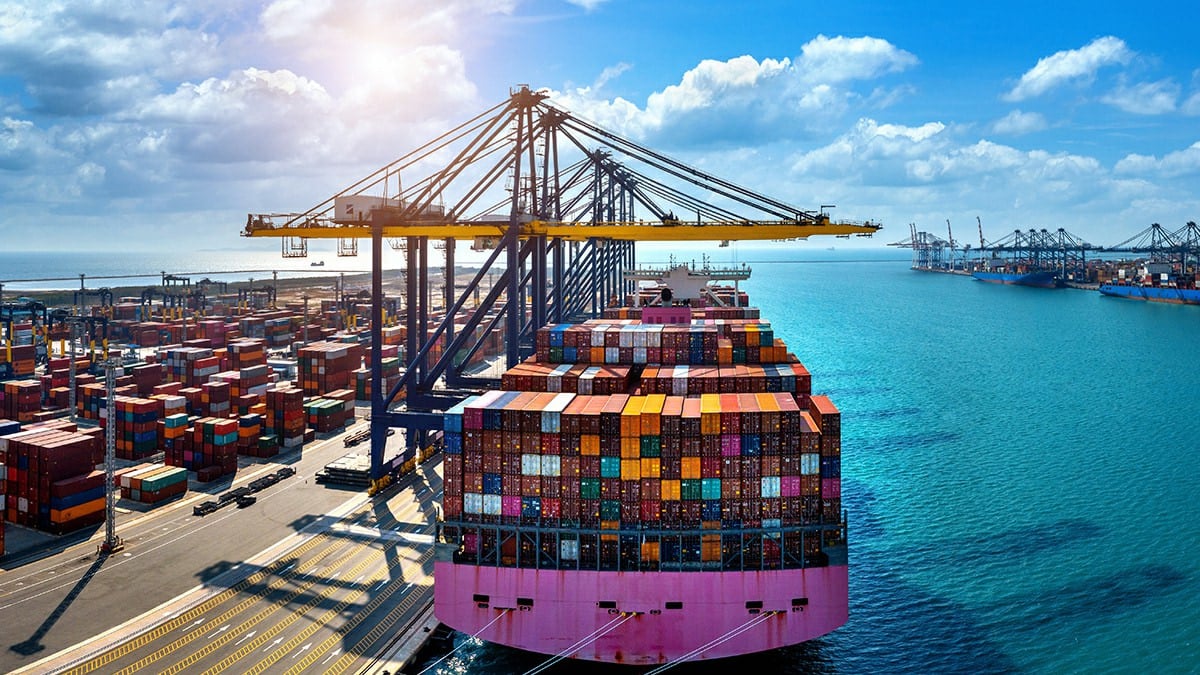 Container vessel berthed alongside quay cranes at a port terminal